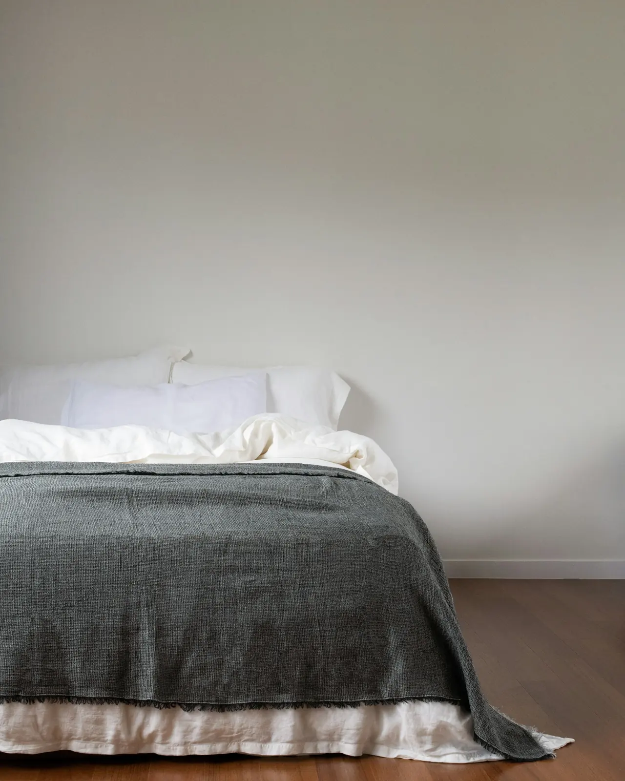 Cama con una manta gris bien hecha