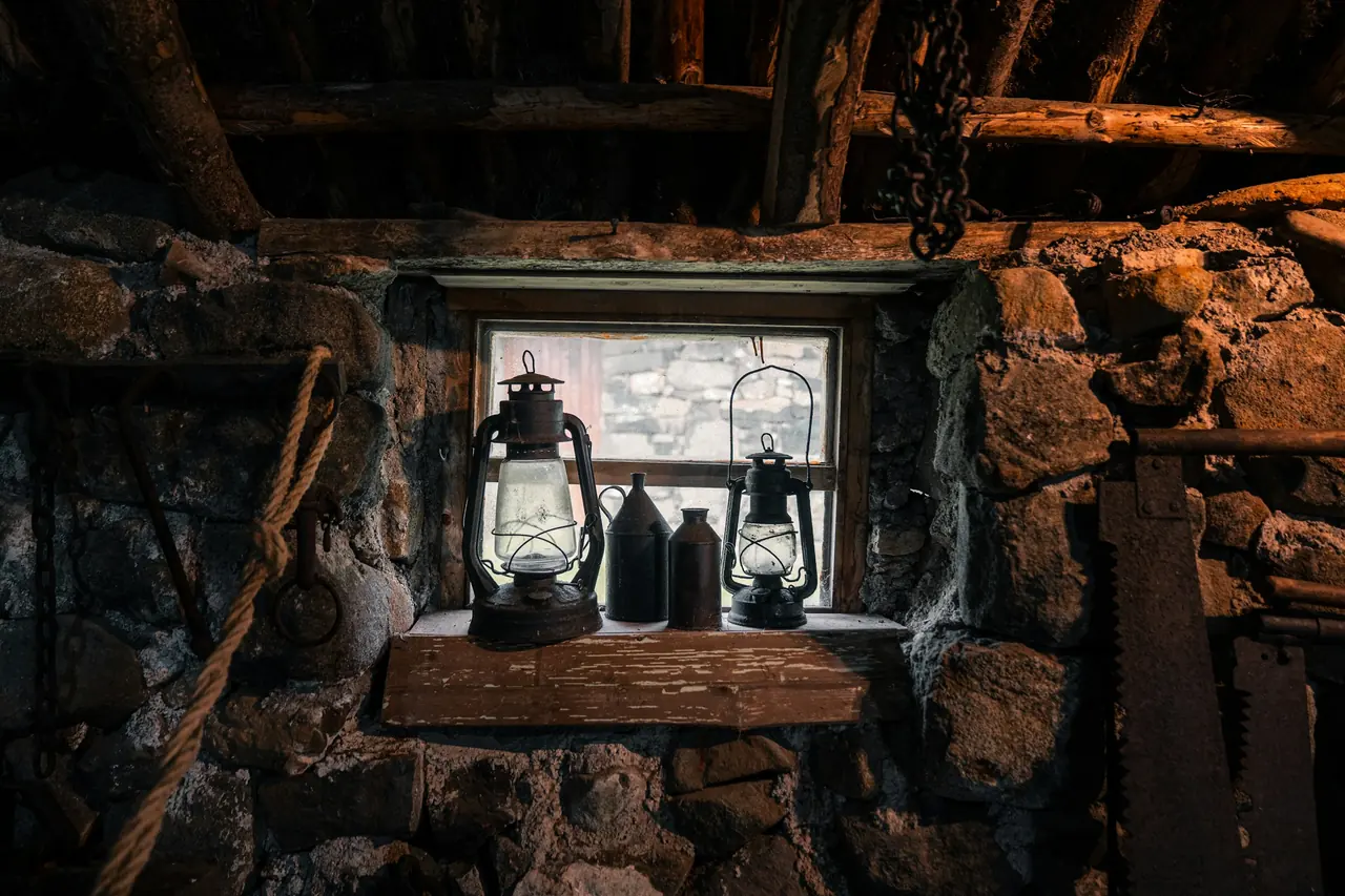 Ventana en un muro de piedra, con un farol