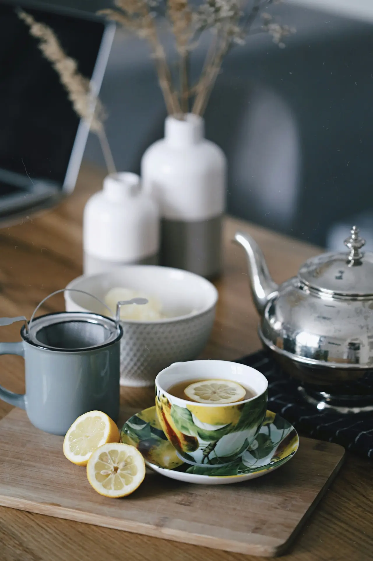 Teapot and a cup of tea beside a lemon